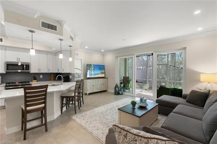 Living area with visible vents, recessed lighting, baseboards, and ornamental molding