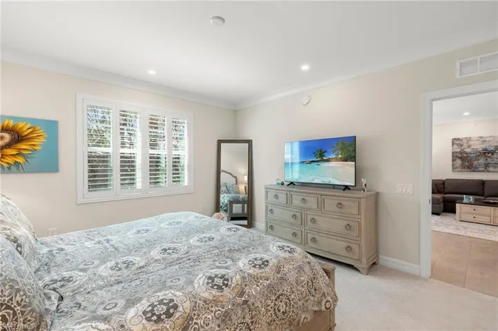 Bedroom featuring visible vents, recessed lighting, crown molding, baseboards, and light colored carpet