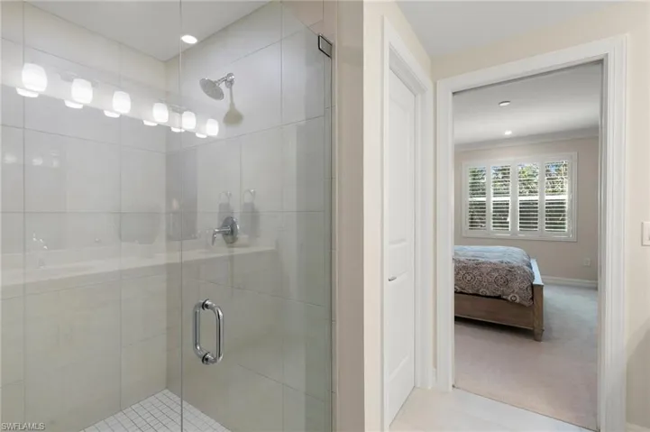 Ensuite bathroom with a shower stall, baseboards, and ensuite bathroom