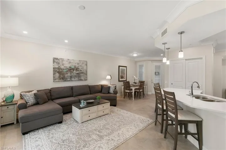 Living area featuring recessed lighting, visible vents, and ornamental molding