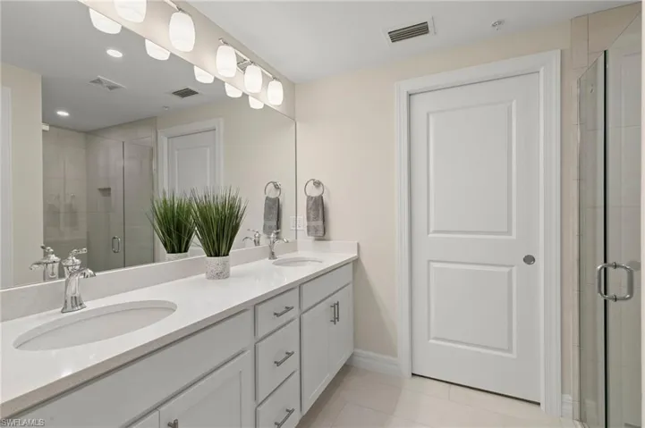 Full bath with a shower stall, visible vents, and a sink