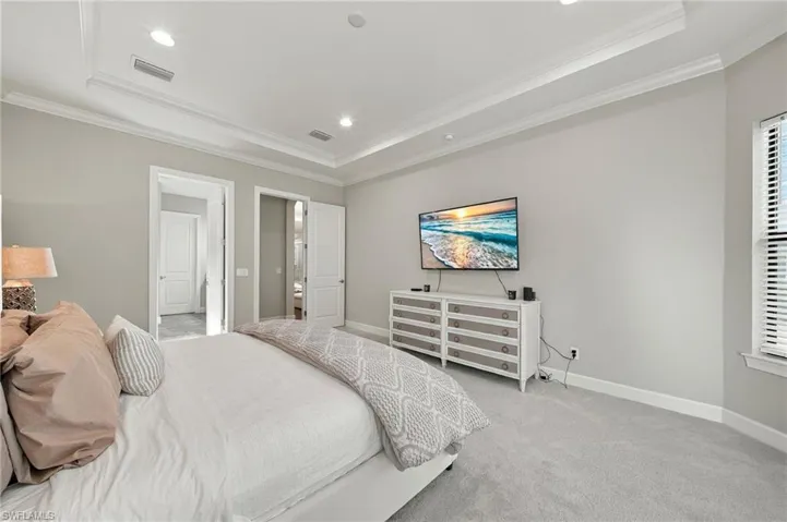 Tray ceiling with crown molding, recessed lighting, and wall-to-wall carpeting