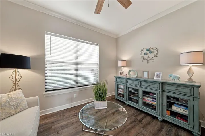 Neutral wall color, wood-finish flooring, ceiling fan, and crown molding
