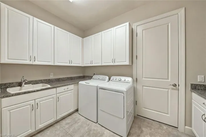 Laundry room featuring white cabinetry, stone-finish countertops, an undermount sink with a gooseneck faucet, and tile flooring