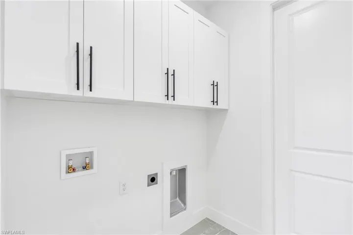 Washroom featuring cabinets, hookup for a washing machine, and hookup for an electric dryer