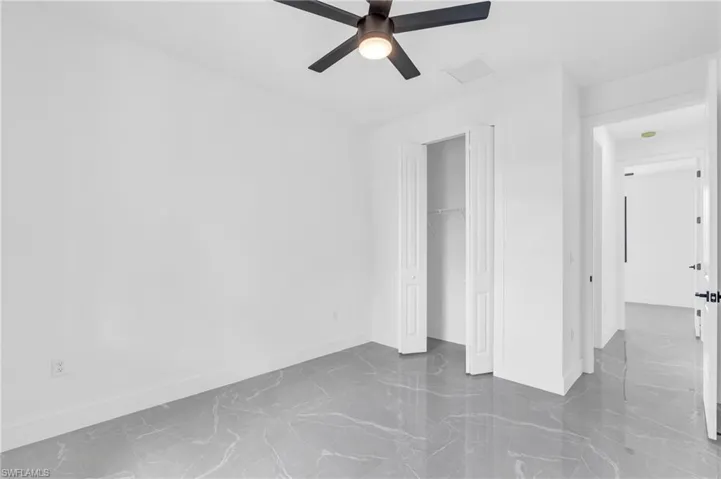 Empty room with a raised ceiling and ceiling fan