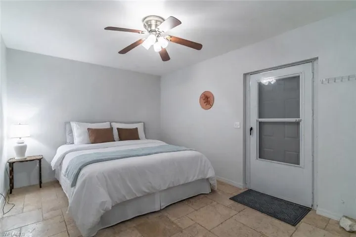 Bedroom featuring stone tile floors and ceiling fan
