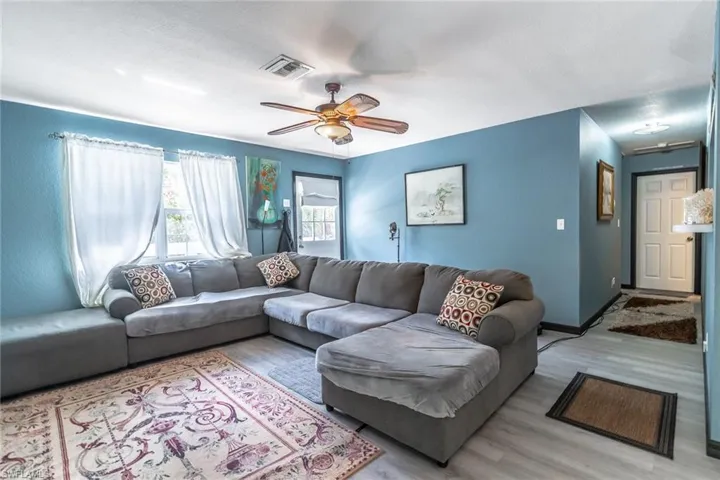 Living area with wood-style LVP floors and a ceiling fan
