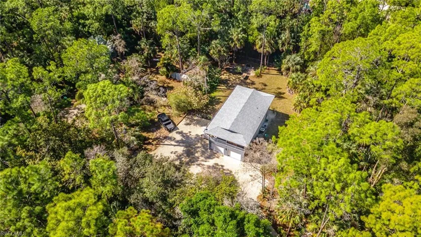 View from above of property with a tree filled landscape
