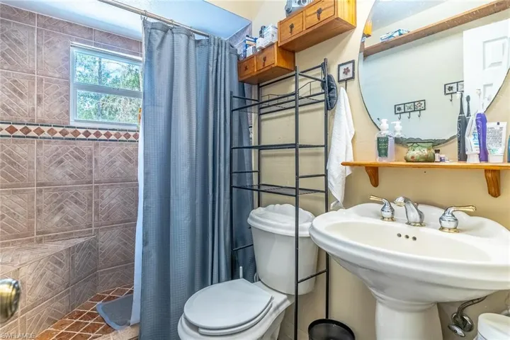 Full bathroom with toilet and a stall shower