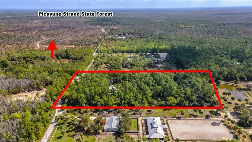Aerial view of property location and property parcel outlined showing forest and trails