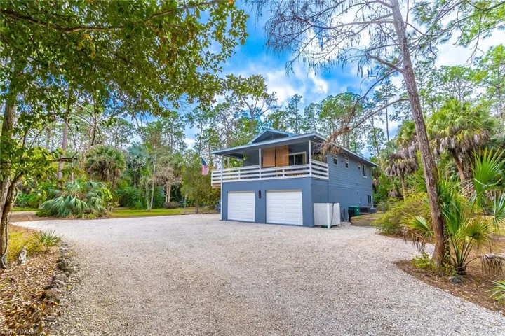 View of front facade with gravel driveway, an attached garage.