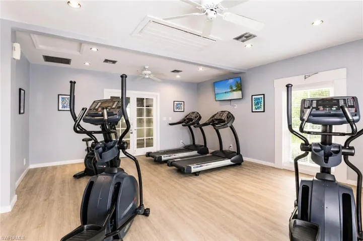 Dedicated fitness space featuring wood-finish flooring and light gray walls