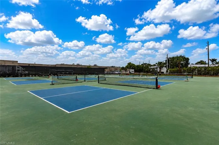 Community courts featuring multiple blue-surfaced playing areas with white line markings, surrounded by green court surfacing