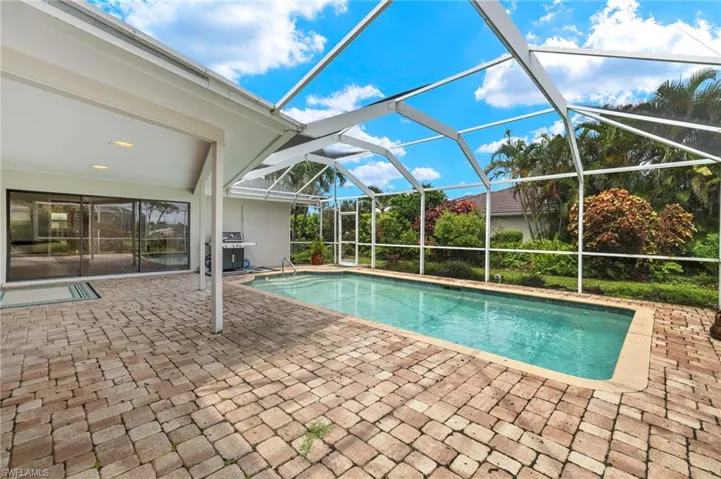 Outdoor pool with a patio, a lanai, and a grill