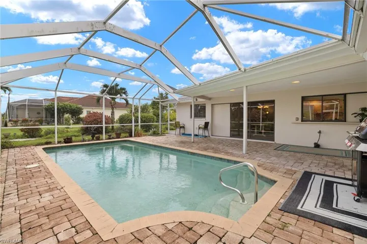 Outdoor pool featuring a patio area and glass enclosure