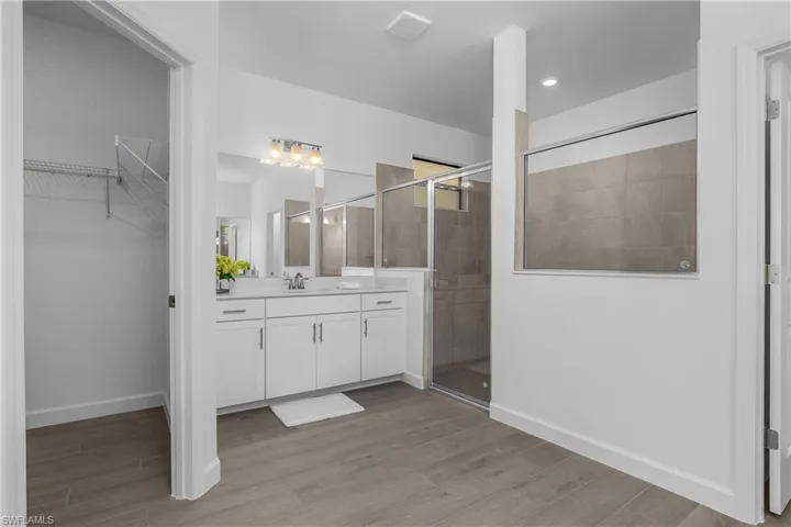 Primary bath features TWO walk-in closets, dual sinks and frameless walk-in shower.