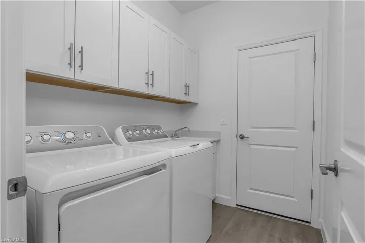 Laundry room includes after-market cabinetry for additional storage and a clean look.