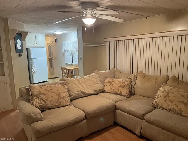Living room featuring ceiling fan and light hardwood / wood-style floors