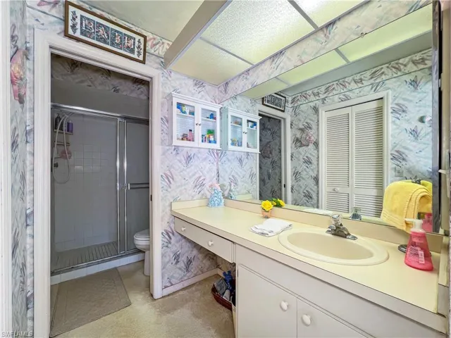 Bathroom featuring toilet, an enclosed shower, and vanity