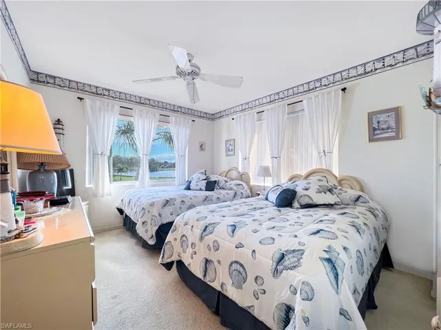 Carpeted bedroom featuring ceiling fan
