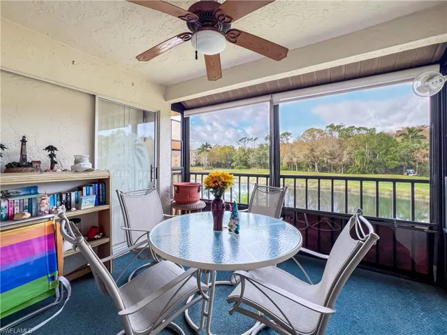 Sunroom with a water view, plenty of natural light, and ceiling fan