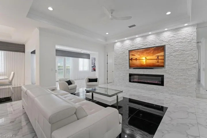 Living space featuring a stacked stone accent wall with an integrated electric fireplace