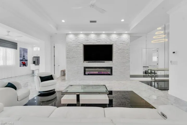 Living area featuring a textured stone-clad media wall with an integrated electric fireplace