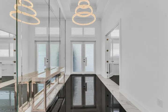 Hallway featuring high-gloss black tile flooring, white walls, and a coffered ceiling