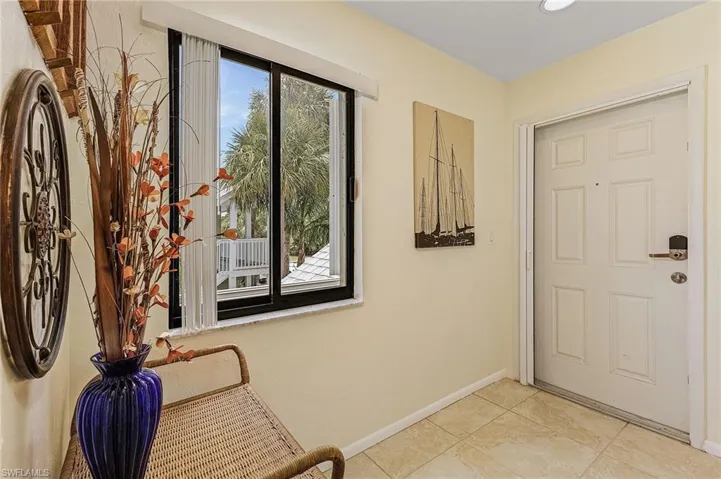 Doorway featuring baseboards and light tile patterned floors