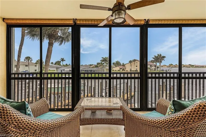 Sunroom with a residential view and a water view