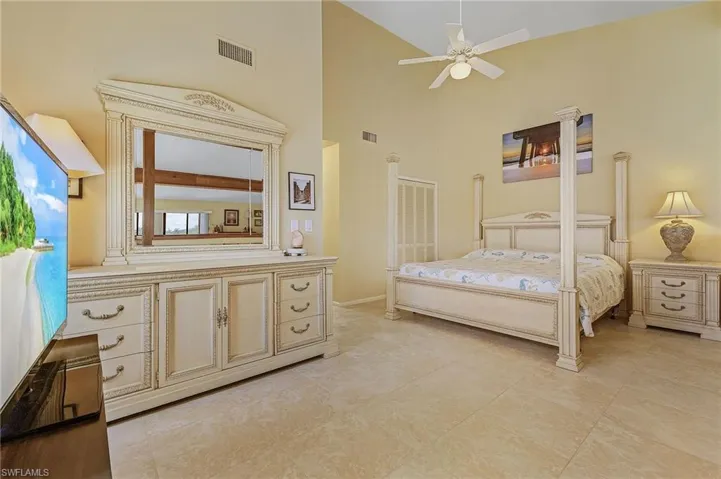 Bedroom featuring visible vents, high vaulted ceiling, and light tile patterned flooring