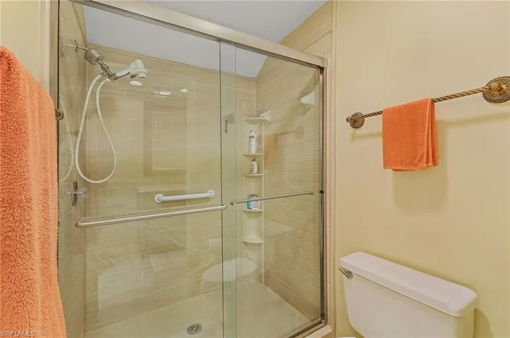 Bathroom featuring a shower stall and toilet