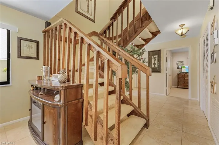 Stairway with baseboards and tile patterned flooring
