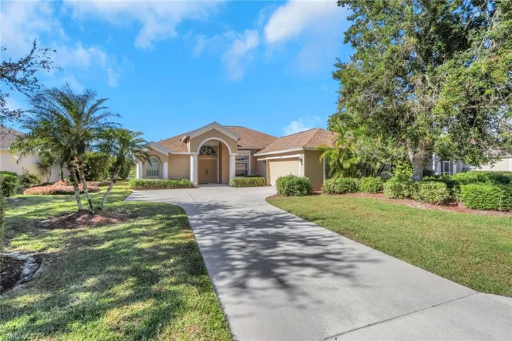 Mediterranean / spanish-style house featuring driveway, stucco siding, a garage, and a front lawn