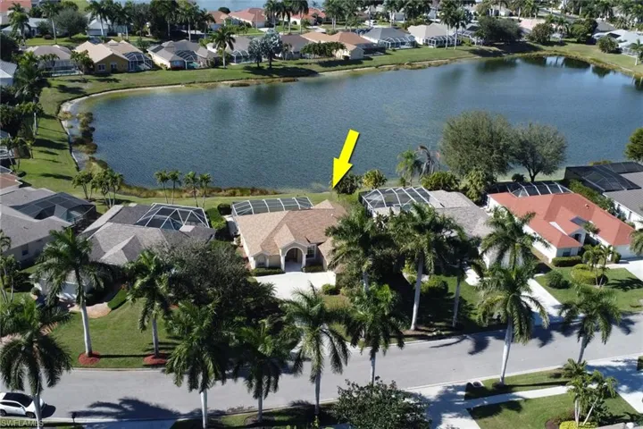 Aerial view of property's location with a nearby body of water and nearby suburban area