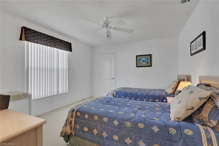 Carpeted bedroom featuring a ceiling fan and baseboards