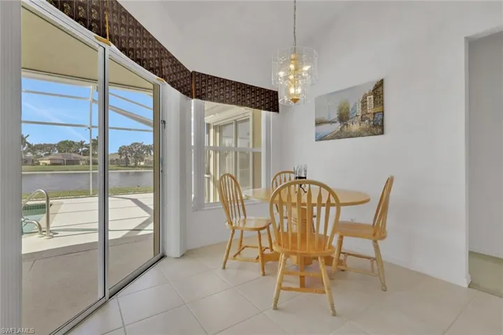 Dining area featuring a water view, a chandelier, and light tile patterned flooring