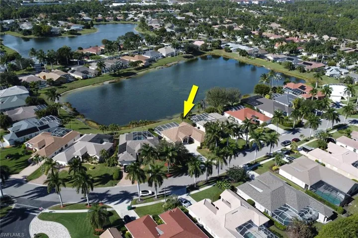 Aerial view of property and surrounding area featuring nearby suburban area and a large body of water