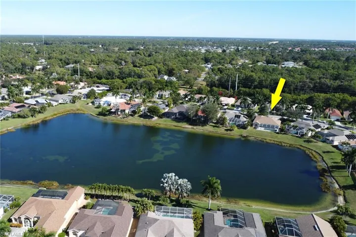 Aerial view of property and surrounding area with a large body of water and nearby suburban area