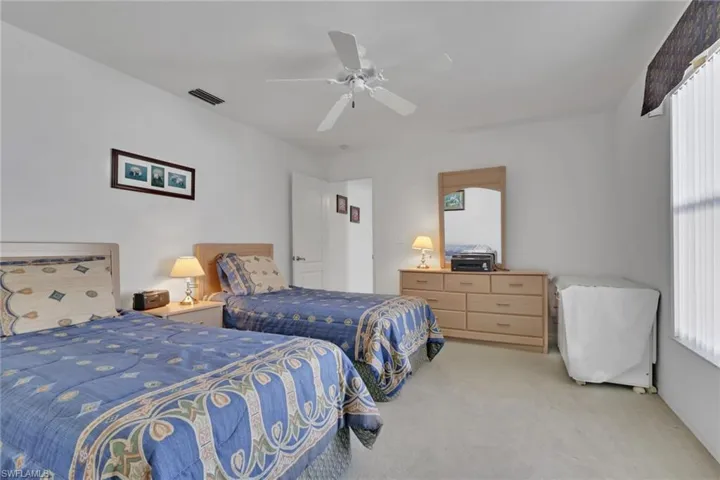 Carpeted bedroom featuring a ceiling fan