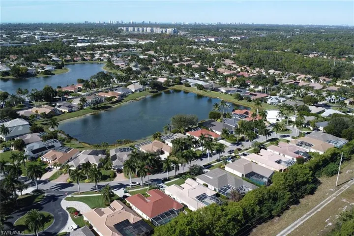 Aerial view of property and surrounding area featuring a nearby body of water and nearby suburban area
