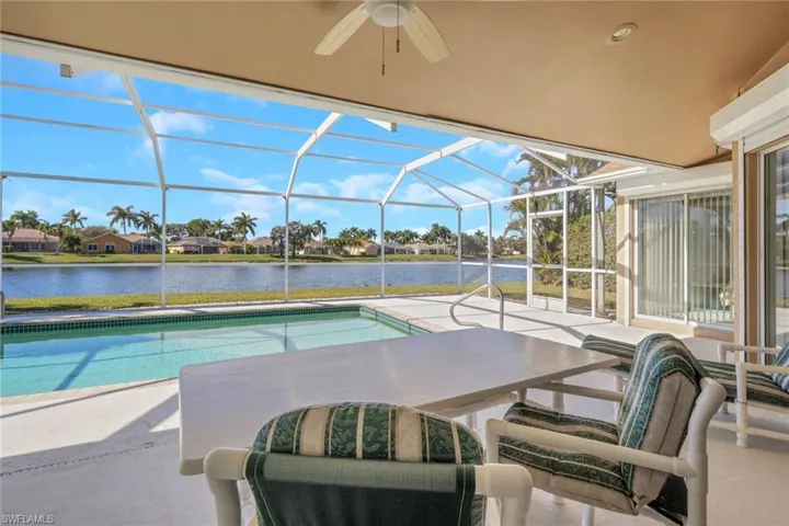 Outdoor pool featuring a lanai, a water view, a sunroom, and a patio area