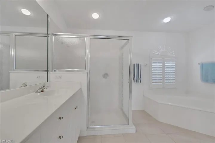 Full bathroom featuring a garden tub, vanity, a stall shower, and light tile patterned floors