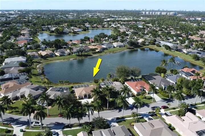Aerial view of property and surrounding area with nearby suburban area and a large body of water