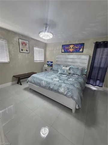 Bedroom with baseboards and tile patterned floors