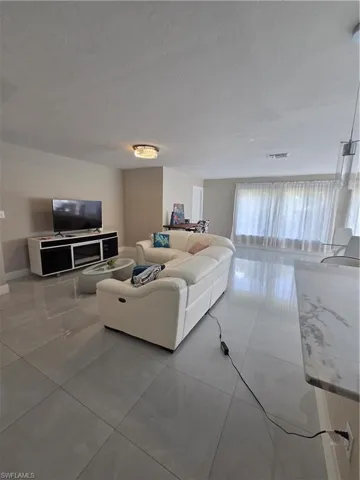 Living area with light tile patterned floors and a textured ceiling