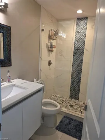 Full bathroom with a shower stall, vanity, and tile patterned floors
