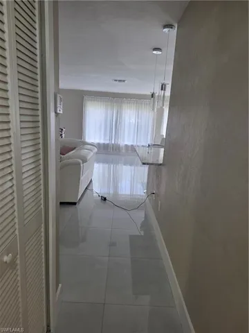 Hall featuring baseboards and a textured wall