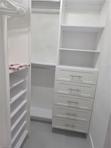 Walk in closet with light tile patterned flooring
